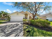 Charming single-story home boasts lush landscaping, mature trees, and a well-maintained two-car garage and inviting entrance at 5290 White Sand Ne Cir, St Petersburg, FL 33703