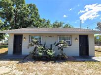 Charming single-story home featuring two front doors, secure window bars, and a neatly landscaped yard at 5401 E 14Th Ave, Tampa, FL 33619