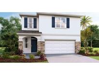 Charming two-story home with blue shutters, stone accents, a two-car garage, and manicured landscaping at 6955 Broad River Ave, Land O Lakes, FL 34638