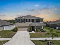 Charming two-story home featuring a well-manicured lawn and inviting curb appeal at 718 Tidal Rock Ave, Ruskin, FL 33570