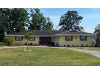 Charming single-story home featuring a well-manicured lawn and a vibrant, welcoming facade with red shutters at 836 Magellan Dr, Sarasota, FL 34243