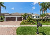 Charming single-story home with a well-manicured lawn, lush landscaping, and a three-car garage at 11910 Keating Dr, Tampa, FL 33626