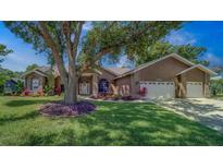 Charming single-story home with a well-manicured lawn and mature landscaping in a desirable neighborhood at 14073 Jennifer Ter, Largo, FL 33774