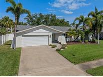 Charming single-story home featuring a two-car garage, well-maintained landscaping, and palm trees at 1849 Del Robles Dr, Clearwater, FL 33764