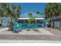 Charming beach house with a playful marlin decoration and an inviting, bright blue, covered front porch at 2613 Upton S St, Gulfport, FL 33711