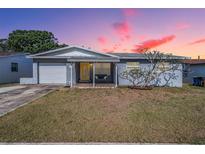 Charming single-story home featuring a cozy front porch swing and well-maintained lawn under a colorful sky at 4160 30Th N St, St Petersburg, FL 33714