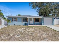 Charming single-story home with blue siding, wood shutters, and a well-manicured front yard at 4232 N Sandalwood Cir, Tampa, FL 33617
