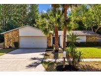 Charming single-story home featuring stone accents, lush landscaping, and an attached two-car garage at 4507 Fox Hunt Dr, Tampa, FL 33624
