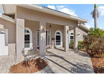 Inviting front entrance with arched windows, neutral color palette, and updated brick pavers at 4531 44Th S St, St Petersburg, FL 33711