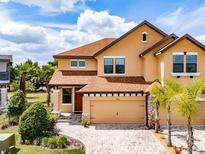 Inviting two-story home with a well-manicured lawn, mature trees and brick paved driveway at 4730 Wandering Way, Wesley Chapel, FL 33544