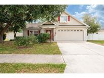 Charming single-Gathering home with a well-maintained lawn, mature trees, and a two-car garage at 6216 Evansbrook Dr, Zephyrhills, FL 33541