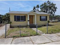 Charming single-story home featuring a fenced yard, yellow paint, and a welcoming front porch at 718 Paris S Ave, St Petersburg, FL 33701