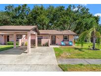 Charming single-story home with a covered parking area, and colorful chairs on the front lawn at 7203 55Th N Ave, St Petersburg, FL 33709