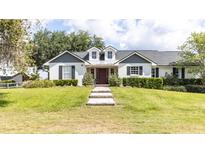 Charming home with a well-manicured lawn, symmetrical landscaping, and inviting brick pathway to the front door at 812 Jameson Rd, Lithia, FL 33547