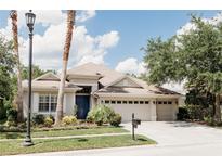 Charming single-Gathering home with a well-manicured lawn and a three-car garage on a sunny day at 8338 Old Town Dr, Tampa, FL 33647