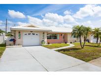 Charming single-story home with a well-manicured lawn, inviting walkway, and attached garage at 11225 59Th Ave, Seminole, FL 33772