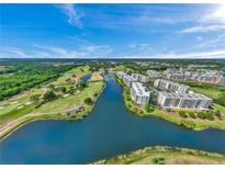 Beautiful aerial view overlooking a golf course, lake, and modern condo buildings on a sunny day at 1200 Country Club Dr # 5506, Largo, FL 33771
