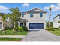 Charming two-story home with a blue garage door and beautifully landscaped front yard at 13981 Lilac Sky Ter, Bradenton, FL 34211