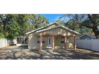 Charming single-story home with inviting front porch and well-maintained yard and a screened porch to the left at 1708 E Genesee St, Tampa, FL 33610