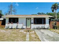 Charming home with a light green door, stone pathway, and landscaped yard at 212 41St S St, St Petersburg, FL 33711