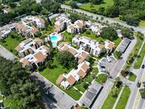 Attractive aerial view of the condo buildings, pool, landscaping, and parking lot in this beautiful residential community at 2211 Belleair Rd # D3, Clearwater, FL 33764