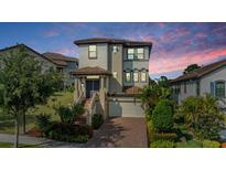 Elegant two-story home featuring landscaped yard, brick driveway, and covered entryway at 3585 Torino Ln, Palm Harbor, FL 34683