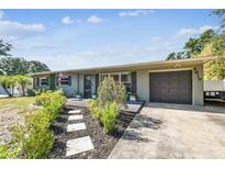 Charming single-story home featuring a well-maintained yard and attached garage with mature landscaping at 4610 W Mcelroy Ave, Tampa, FL 33611
