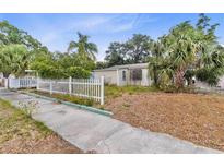 Charming single-story home with a white picket fence and mature palm trees in the front yard at 536 Braddock S St, St Petersburg, FL 33707