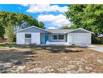 Charming one-story home with a well-maintained front yard and a bright blue front door at 6017 6Th Ave, New Port Richey, FL 34653