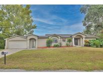Charming single-story home featuring an attached garage, well-maintained lawn, and inviting curb appeal at 9421 Sunshine Blvd, New Port Richey, FL 34654