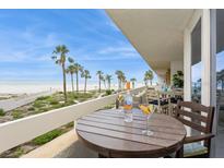Enjoy ocean views from the spacious balcony with seating and beautiful palm trees at 17900 Gulf Blvd # 1B, Redington Shores, FL 33708