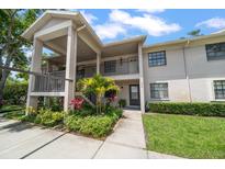 Inviting two-story condo featuring lush landscaping, an open walkway, and neutral color palette at 2170 Elm St # 906, Dunedin, FL 34698