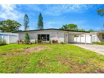 Charming one-story home featuring a lush green lawn and covered carport, plus eye-catching curb appeal at 219 80Th Ne Ave, St Petersburg, FL 33702