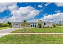 Charming one-story home with a well-manicured lawn and inviting blue front door at 2324 Hayworth Rd, Port Charlotte, FL 33952