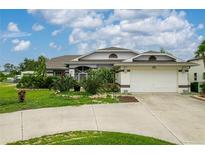Charming single-story home with a two-car garage and well-manicured landscaping at 23420 Peachland Blvd, Port Charlotte, FL 33954