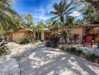 Inviting home features a charming blend of stone accents, lush tropical landscaping and a welcoming driveway at 44 Pinewood Cir, Safety Harbor, FL 34695