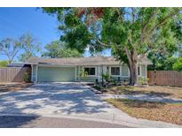 Charming single-story home with a well-maintained lawn, mature trees, and a welcoming two-car garage at 506 Summerwood Ct, Tarpon Springs, FL 34689