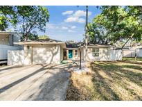Charming single-story home with a well-manicured lawn, blue front door, and a two-car garage at 7012 S Trask St, Tampa, FL 33616