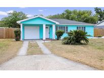 Charming, turquoise-colored one-story home with a well-manicured front yard and an attached single-car garage at 115 S Saturn Ave, Clearwater, FL 33755