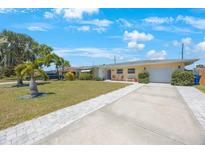 Charming single-story home featuring a lush front yard, covered entryway, and a convenient attached garage at 11619 80Th Ave, Seminole, FL 33772