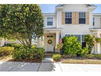 Charming two-story home featuring a welcoming porch, lush landscaping, and a patriotic American flag display at 12323 Country White Cir, Tampa, FL 33635