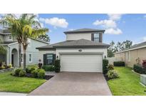 Charming two-story home with a well-maintained front yard and brick driveway at 19400 Roseate Dr, Lutz, FL 33558