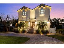 Stunning two-story home with brick paved driveway, lush landscaping, and illuminated exterior at 2303 S Occident St, Tampa, FL 33629