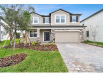 Charming two-story home with stone accents, manicured landscaping, and a paved driveway at 38190 Shale Stone Ct, Zephyrhills, FL 33540