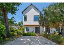 Charming two-story home with white siding, modern windows, and lush landscaping, enhancing its curb appeal at 411 W Frances Ave # 2, Tampa, FL 33602