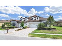 Charming single-story home with a three-car garage, complemented by lush landscaping and a brick driveway at 4300 Barletta Ct, Wesley Chapel, FL 33543