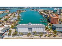 Stunning aerial view of waterfront condo building with boat docks and city skyline in the background at 445 Hamden Dr # 502, Clearwater Beach, FL 33767