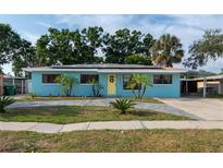 Charming home featuring a tidy front yard, new driveway, and bright yellow front door at 4721 W Iowa Ave, Tampa, FL 33616