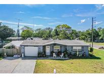 Charming single-story home with a well-manicured lawn and covered front porch seating area at 5004 Suwannee Dr, New Port Richey, FL 34652