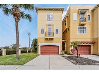 Charming three-story home with a terracotta garage door, balcony, and well-manicured lawn with a palm tree at 6404 Mayra Shores Ln, Apollo Beach, FL 33572